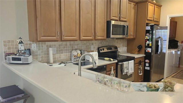 kitchen featuring independent washer and dryer, appliances with stainless steel finishes, and decorative backsplash