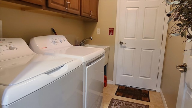 laundry area featuring sink, washing machine and dryer, and cabinets