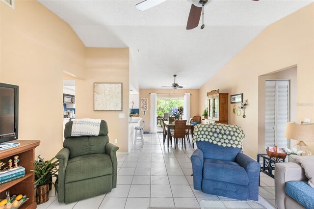 living room featuring light tile patterned flooring, a textured ceiling, ceiling fan, and vaulted ceiling