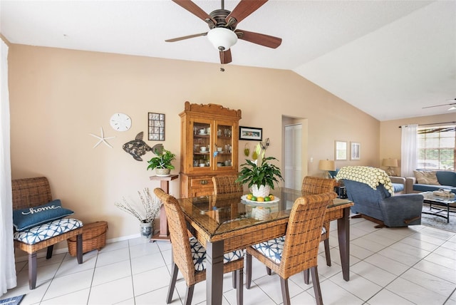 tiled dining area featuring ceiling fan and vaulted ceiling