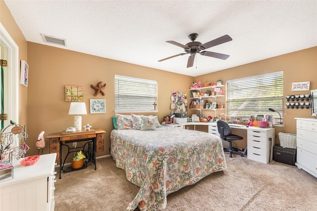 bedroom featuring light carpet, a textured ceiling, and ceiling fan