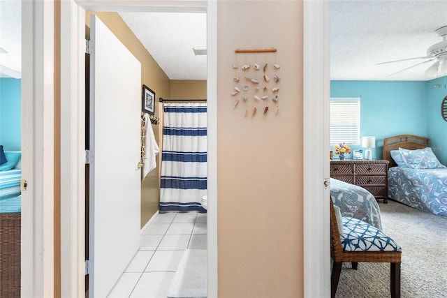 hall with light tile patterned floors and a textured ceiling