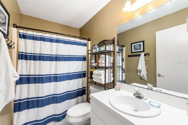 bathroom with toilet, vanity, and a textured ceiling