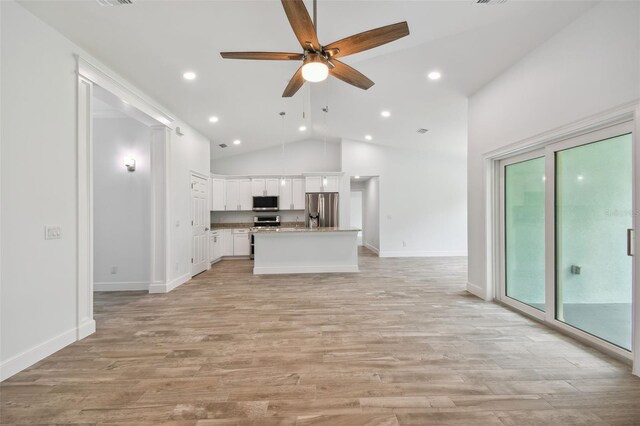 unfurnished living room with high vaulted ceiling, light wood-type flooring, ceiling fan, and a wealth of natural light