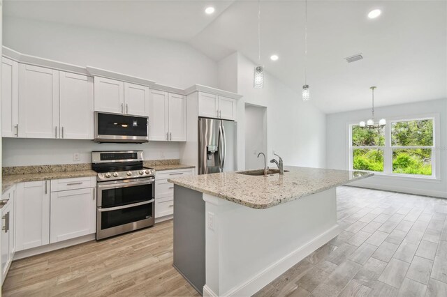 kitchen featuring white cabinets, light wood-type flooring, sink, appliances with stainless steel finishes, and a kitchen island with sink