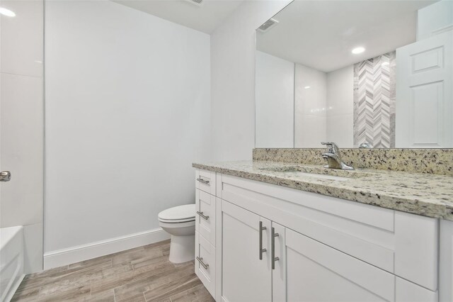 bathroom with vanity, wood-type flooring, and toilet