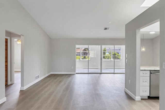 unfurnished living room with light wood-type flooring, visible vents, and baseboards