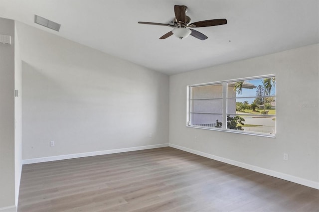 spare room with visible vents, ceiling fan, baseboards, and wood finished floors