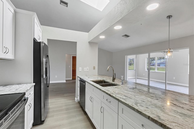 kitchen with appliances with stainless steel finishes, white cabinets, a sink, and visible vents