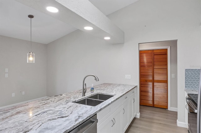 kitchen featuring white cabinets, electric range oven, hanging light fixtures, light stone countertops, and a sink