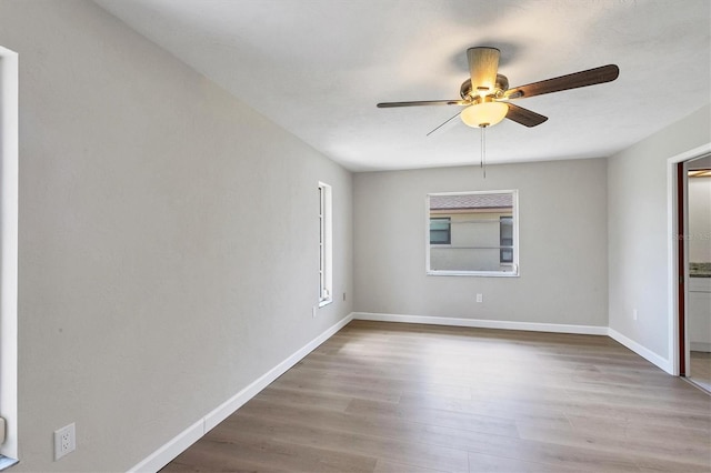 unfurnished room featuring ceiling fan, wood finished floors, and baseboards