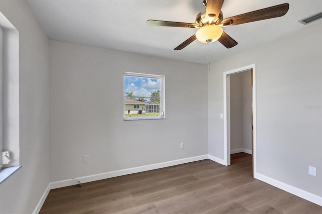 unfurnished room featuring visible vents, ceiling fan, baseboards, and wood finished floors