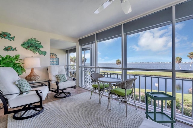 sunroom / solarium featuring a water view and a ceiling fan