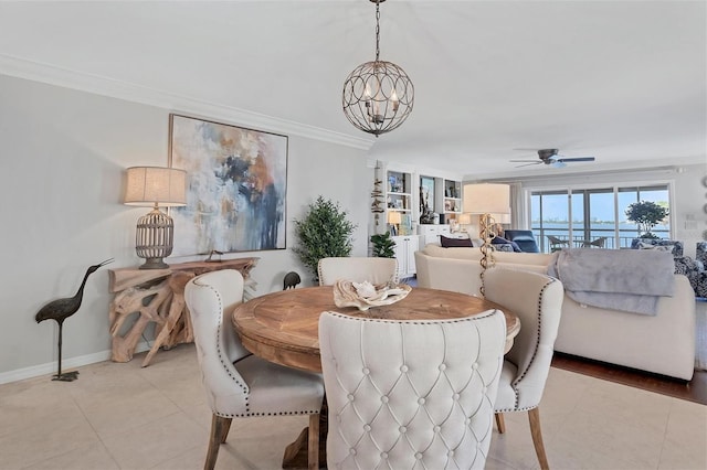 dining area featuring ceiling fan with notable chandelier, ornamental molding, light tile patterned flooring, and baseboards