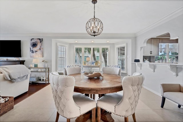 dining space featuring a chandelier, tile patterned flooring, a wealth of natural light, and crown molding