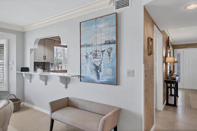 living area with baseboards, light tile patterned floors, visible vents, and crown molding