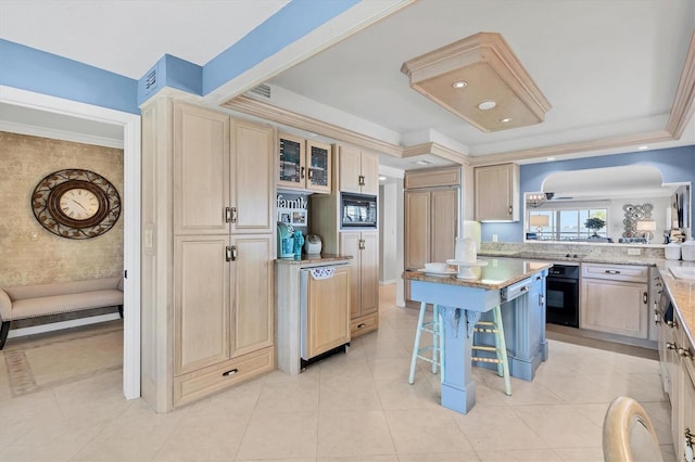 kitchen with glass insert cabinets, ornamental molding, a kitchen breakfast bar, black appliances, and light tile patterned flooring