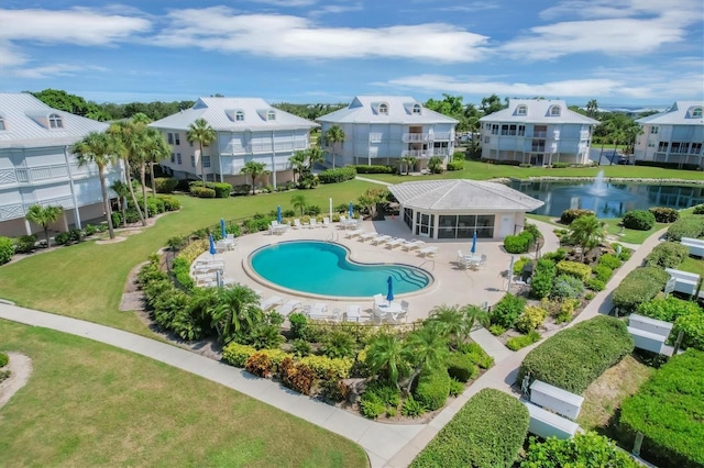 view of pool featuring a patio area, a lawn, a water view, and a residential view