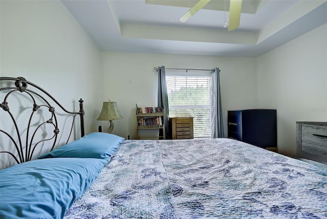 bedroom featuring ceiling fan and a raised ceiling