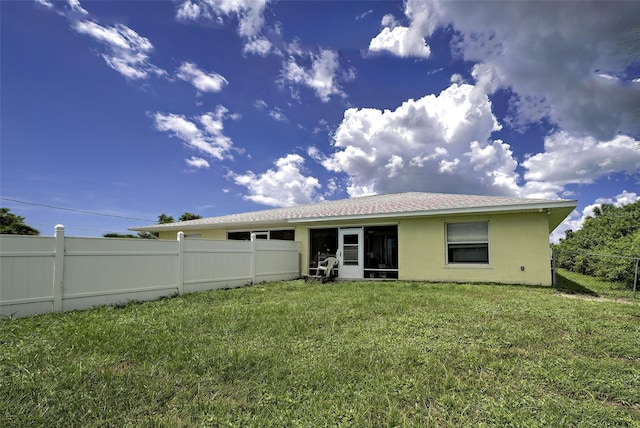 rear view of house featuring a yard