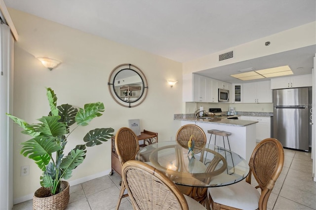 tiled dining space featuring sink