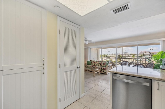 kitchen with light tile patterned flooring, dishwasher, light stone counters, and ceiling fan