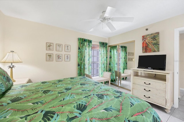 bedroom with light tile patterned flooring, ceiling fan, and a closet