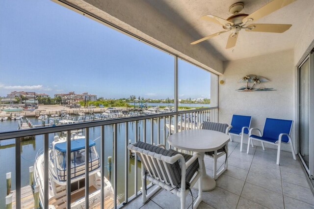 balcony featuring a water view and ceiling fan