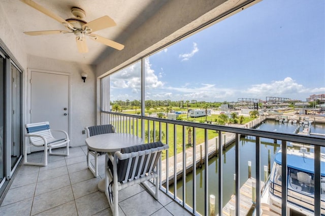 balcony featuring a water view, a boat dock, and ceiling fan