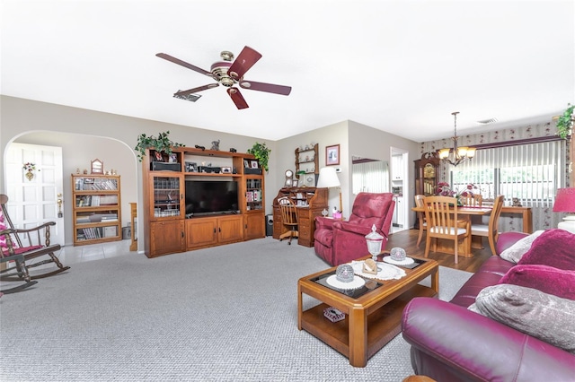 living room with carpet flooring and ceiling fan with notable chandelier