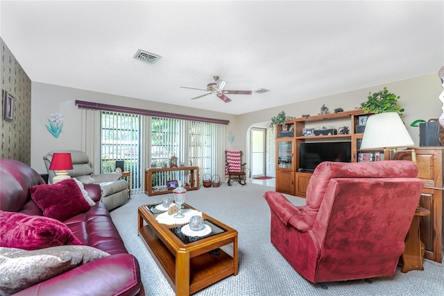 living room featuring a ceiling fan, a textured ceiling, visible vents, and carpet flooring