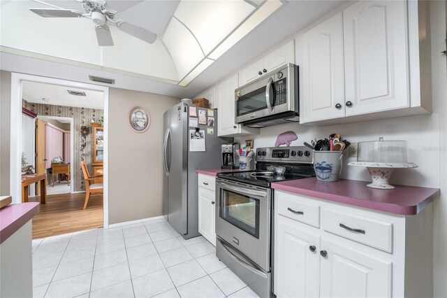 kitchen featuring appliances with stainless steel finishes, white cabinetry, light tile patterned floors, and ceiling fan