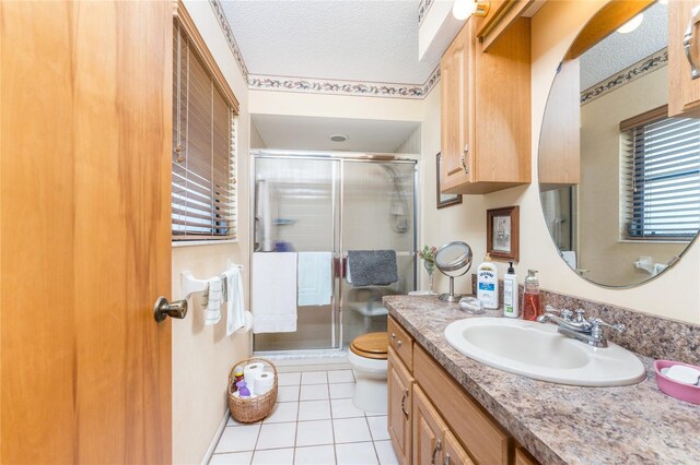 bathroom with an enclosed shower, tile patterned flooring, a textured ceiling, toilet, and vanity