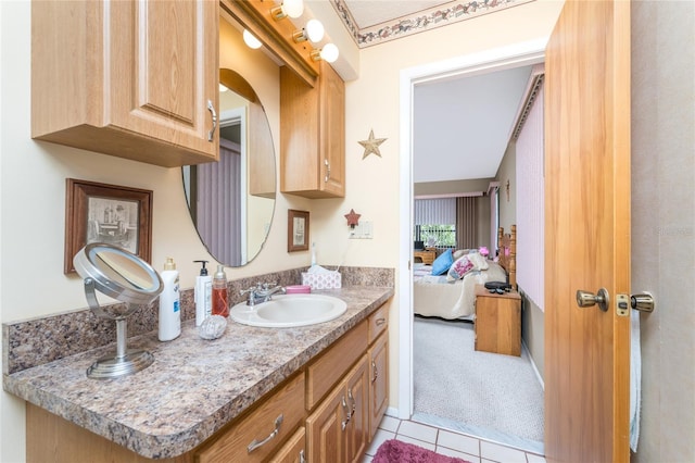 bathroom with ensuite bath, vanity, and tile patterned floors