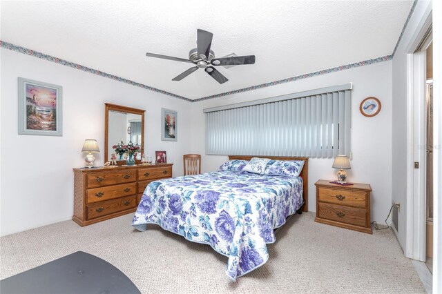 carpeted bedroom featuring a textured ceiling and ceiling fan