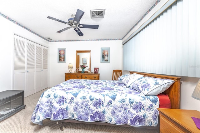 bedroom featuring a textured ceiling, ceiling fan, carpet flooring, and a closet