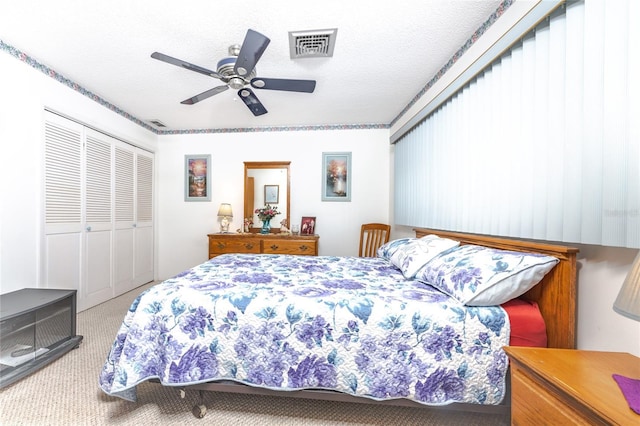 carpeted bedroom featuring a closet, visible vents, and a textured ceiling