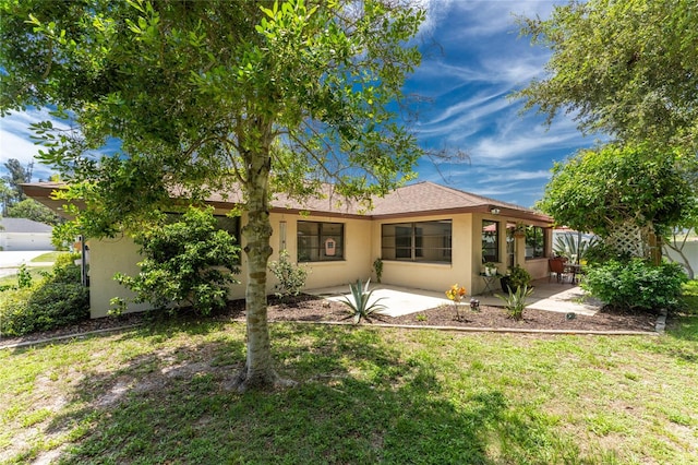 rear view of property featuring a lawn and a patio area