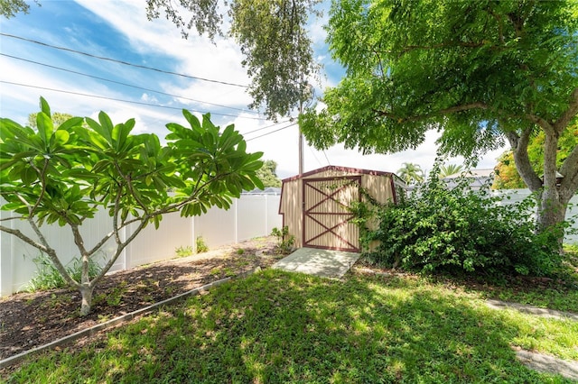 view of yard with a shed, a fenced backyard, and an outdoor structure