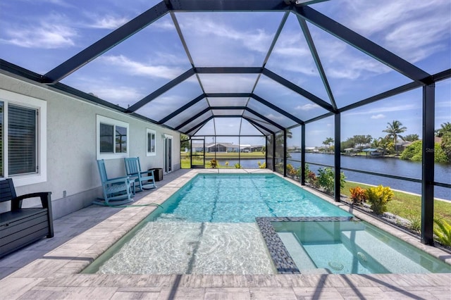 view of pool with a patio area, an in ground hot tub, a water view, and glass enclosure