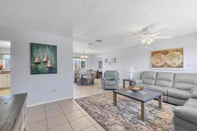 living room featuring light tile patterned flooring, a textured ceiling, and ceiling fan with notable chandelier