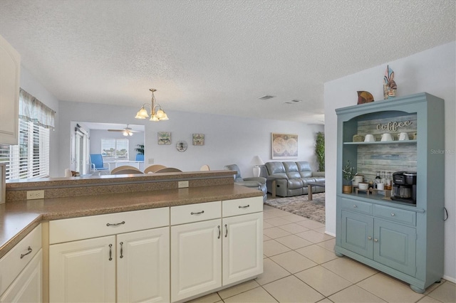 kitchen featuring light tile patterned flooring, a chandelier, and a textured ceiling