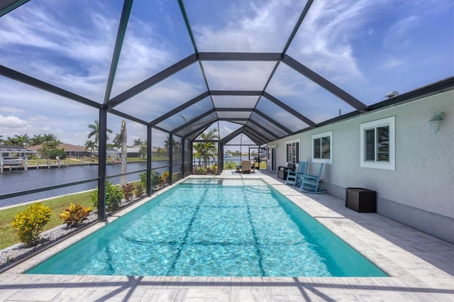 view of pool with a lanai, a water view, and a patio area