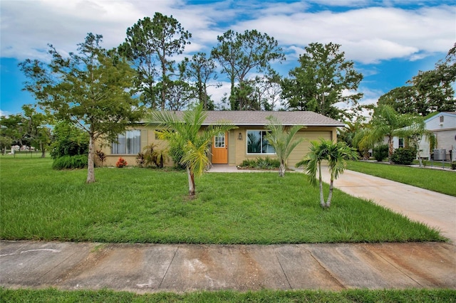 ranch-style house with cooling unit, a garage, and a front yard