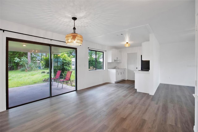 unfurnished living room featuring wood-type flooring and sink