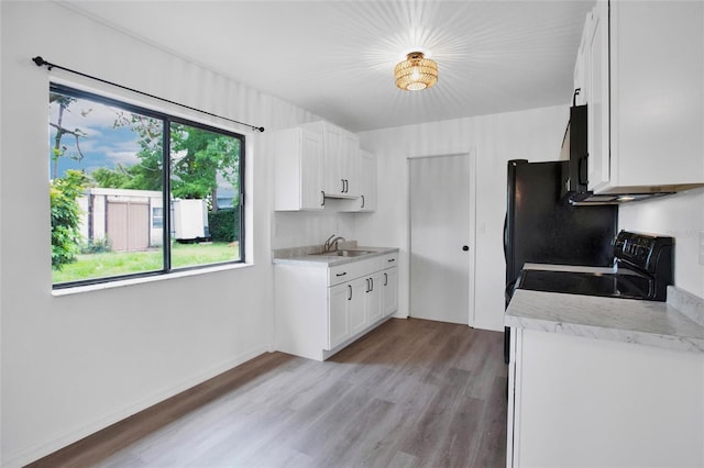 kitchen with white cabinetry, sink, black electric range, and light wood-type flooring