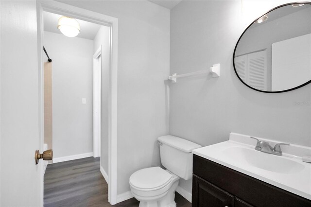 bathroom featuring vanity, hardwood / wood-style flooring, toilet, and walk in shower