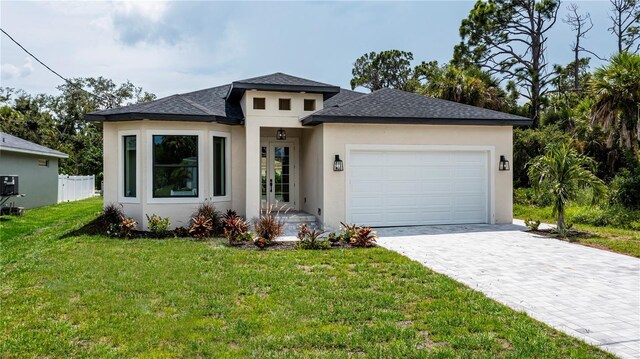 prairie-style house featuring a front lawn and a garage