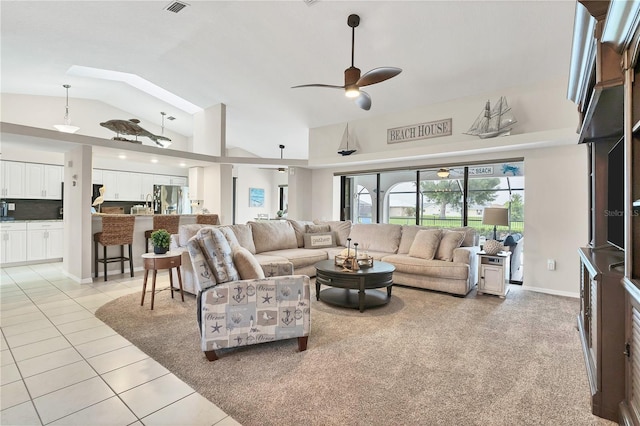 living room featuring ceiling fan, vaulted ceiling, and light tile patterned floors