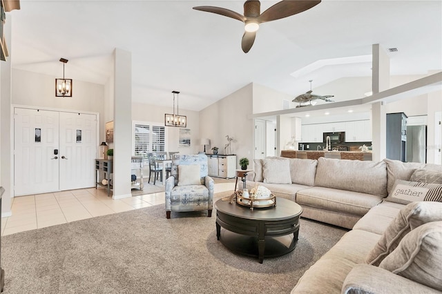 living room featuring light tile patterned flooring, ceiling fan with notable chandelier, and lofted ceiling